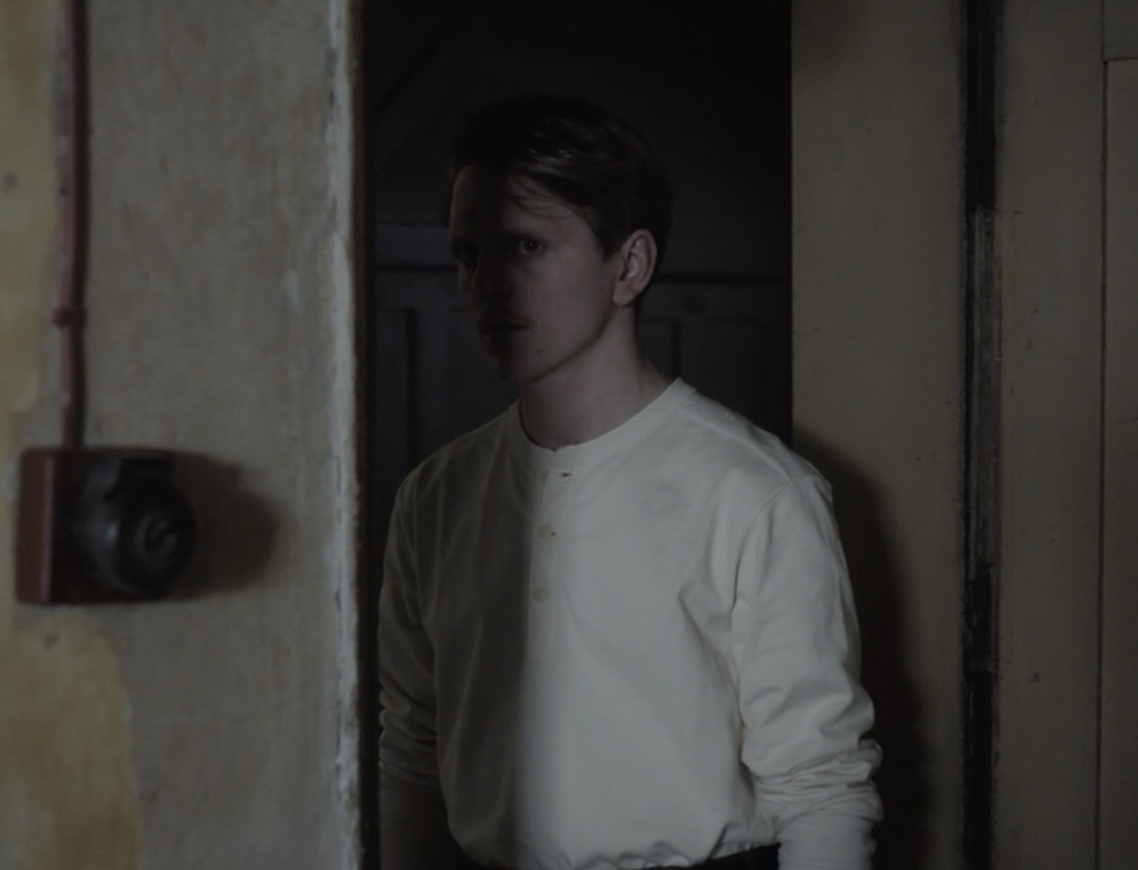 Scene form the film Elsa showing man in doorway in half shadow.